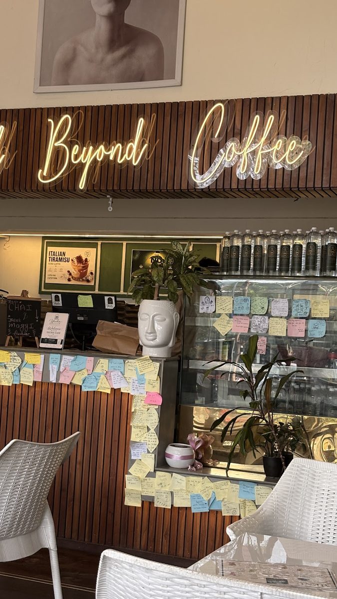 Yecha's wall covered in guests' sticky notes under the neon 'Crafted Beyond Coffee' sign